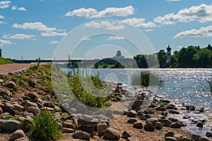 Pskov, Russia, September 6, 2023. Stones on the river bank and a view of the bridge in the city center.