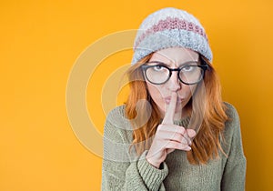 Psst. Young woman holding finger on lips, keep the secret concept, isolated on white background photo