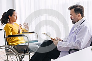 Psychiatrist doctor collect data talk with patient on wheelchair for mental care health problems check followup in hospital clinic