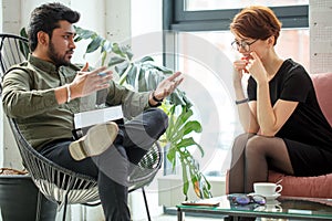 Psychiatrist looking at patient during her visit in his office