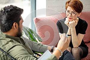 Psychiatrist looking at patient during her visit in his office