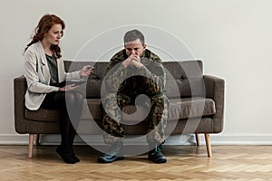 Psychiatrist talking to her angry patient while sitting on a sofa