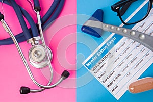 Psychiatry mental status exam, hourglass, reflex hummer and medical stethoscope in two colors background: blue and pink. Concept o photo