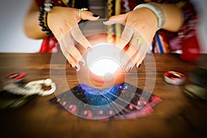 Psychic readings and clairvoyance concept - Crystal ball fortune teller hands and Tarot cards reading divination