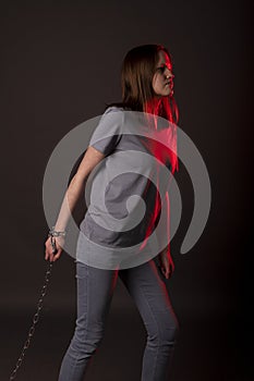 Psychological concept of hard responsibilities, debts and loans. Young woman pulling chain with despair