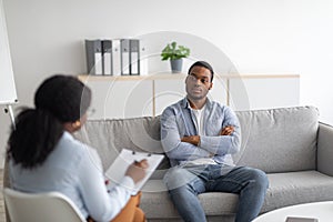 Psychological counselling. Black male patient with depression having session with psychotherapist at office