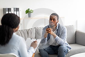 Psychological help service. Depressed male patient having psychotherapy session with counselor at mental health clinic