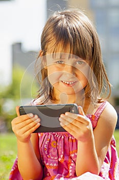 Psychological image of cute little girl addicted to likes: Social networks feeds her neediness. Close up sad child with mobile