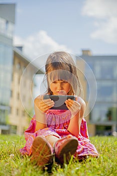 Psychological image of cute little girl addicted to likes: Social networks feeds her neediness. Portrait of child with mobile photo