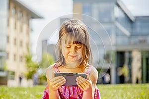 Psychological image of cute little girl addicted to likes: Social networks feeds her neediness. Portrait of child with mobile