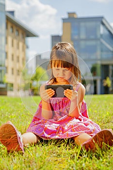 Psychological image of cute little girl addicted to likes: Social networks feeds her neediness. Portrait of nervous child with photo