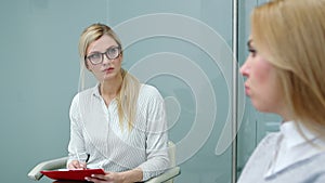 Psychologist is attentively listening client woman talking about her problems at therapy.