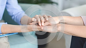 Psychologist consoling her client, holding her hands