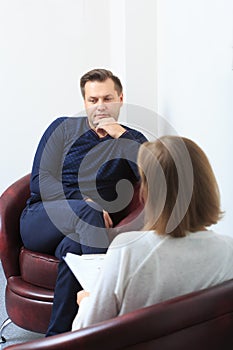 Psychologist consulting pensive man during