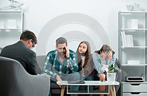 Psychologist helping young family with a child to solve teenagers problems. Family therapy, social service concept.