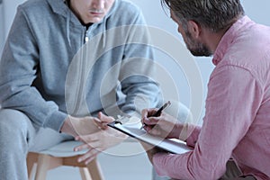 Psychologist interviewing his depressed patient during therapy photo