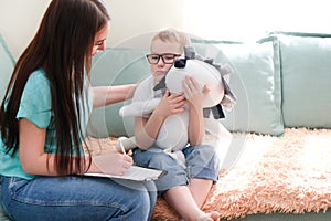 Psychologist listens to a small child during a therapy session