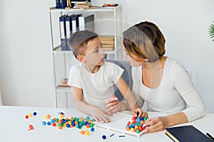 In the psychologist's office, a boy with a teacher learns to develop