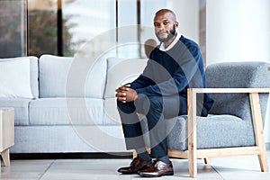 Psychologist, waiting and black man sitting on chair at work, job or modern workplace in modern office lounge. Portrait