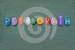 Psychopath, mental illness word composed with multicolored stone letters over green sand