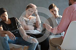 Psychotherapist supporting difficult teenagers during group therapy