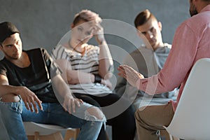 Psychotherapist supporting difficult teenagers during group therapy photo