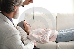 Psychotherapist using pendulum during hypnotherapy   session photo