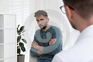 Psychotherapist working with drug addicted man indoors