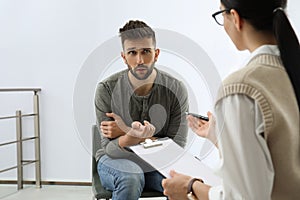 Psychotherapist working with drug addicted man indoors