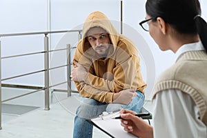 Psychotherapist working with drug addicted man indoors