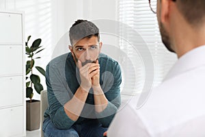 Psychotherapist working with drug addicted man indoors