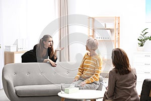 Psychotherapist working with teenage girl and her mother in office