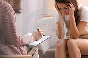 Psychotherapist working with teenage girl in office