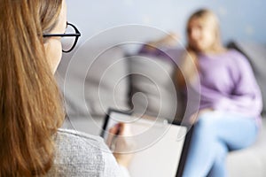 Psychotherapy session, a woman is talking with her psychologist at cozy office. Psychotherapy consultation. Selective focus