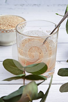 Psyllium husk and a glass of water on a light background