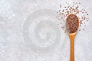 Psyllium Husk seeds , fiber source , in wooden spoon on light stone background. Top view with copy space