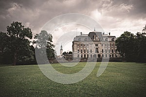 Pszczyna Castle in Poland, Pszczyna on a gloomy day with gray clouds and a green lawn in front