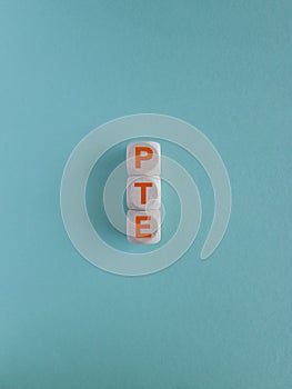 PTE - acronym on cubes with orange letters, Pearson Tests of English PTE concept