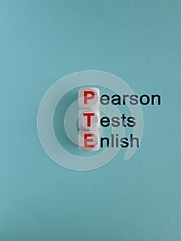 PTE - acronym on wooden cubes with red letters, Pearson Tests of English PTE concept Foreign