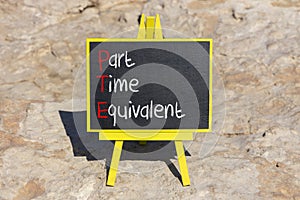 PTE Part time equivalent symbol. Concept words PTE Part time equivalent on beautiful black chalk blackboard. Beautiful stone beach