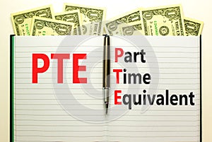 PTE Part time equivalent symbol. Concept words PTE Part time equivalent on white note. Dollar bills. Beautiful white table white