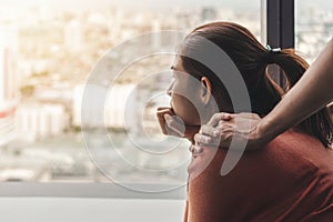 PTSD Mental health concept, Psychologist sitting and touch young depressed asian woman for encouragement near window with low photo