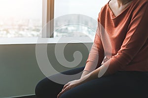 PTSD Mental health concept, Young depressed asian woman sitting alone near window in dark at evening time with low light photo