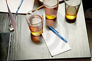 The pub quiz concept. Beer glass and blank paper for answers.