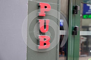 Pub sign text on bar entrance in city europe street storefront facade building