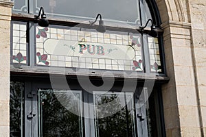 Pub sign text on facade entrance bar city street storefront building