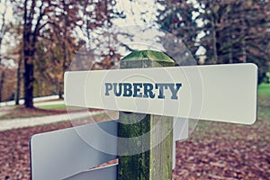 Puberty signboard on a wooden post photo