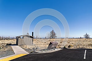 The public bathroom and bear-proof trash receptacles at a parking lot at the Lava Beds National Monument, California, USA