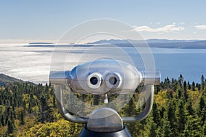 Public binoculars in front of a view over the Forillon Park