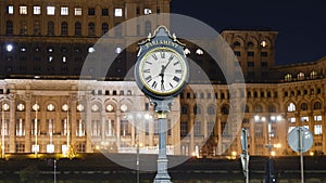 Public clock at Palace of Parliament, Bucharest, Romania, partly illuminated at night to reduce energy costs